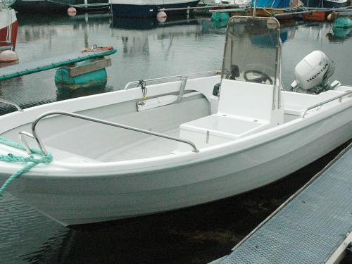 a white boat tied to a dock in the water at 6 person holiday home in Farstad-By Traum in Farstad