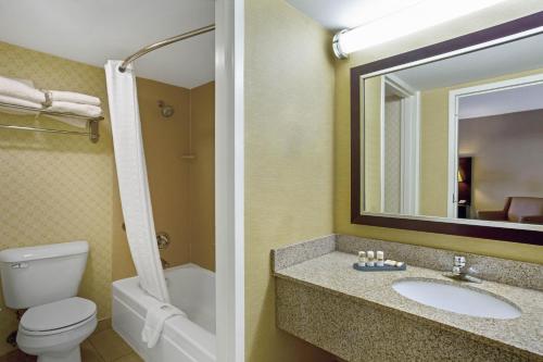 a bathroom with a toilet and a sink and a mirror at La Quinta by Wyndham Manchester in Manchester