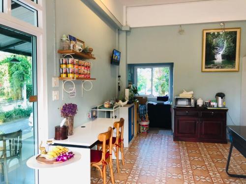 a kitchen with a counter and a table and chairs at Baanlugchange Hotel in Chanthaburi