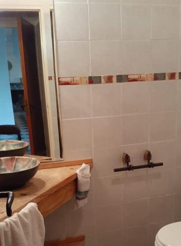 a bathroom with a sink and a mirror and a toilet at Casa de Campo La Renata in El Pato