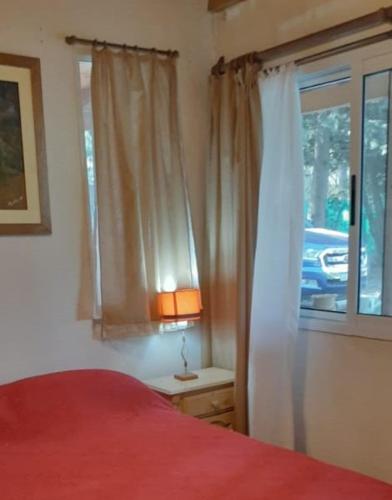 a bedroom with a red bed and a window at Casa de Campo La Renata in El Pato