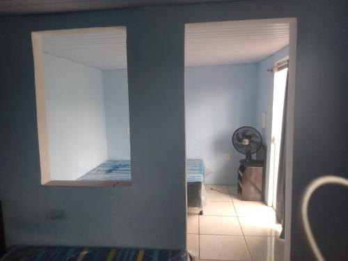 Cette chambre dispose d'un couloir avec un lit et un miroir. dans l'établissement Suíte Familiar, à Arraial do Cabo