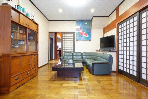a living room with a couch and a tv at 能生の家 in Itoigawa