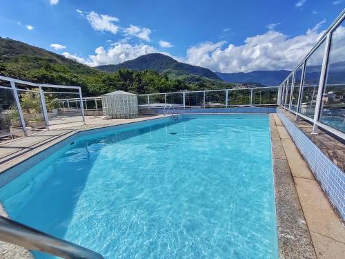 a swimming pool with mountains in the background at Hotel Palace in Cachoeiras de Macacu