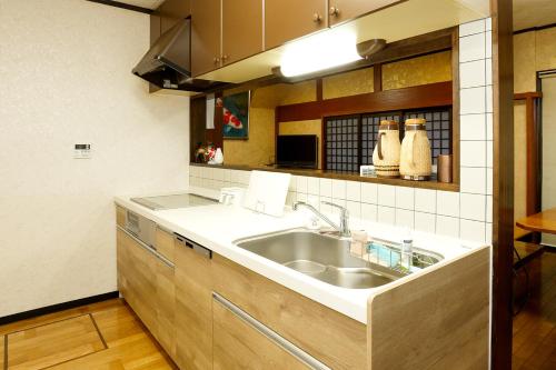 eine Küche mit einer Spüle und einer Theke in der Unterkunft 能生の家 in Itoigawa