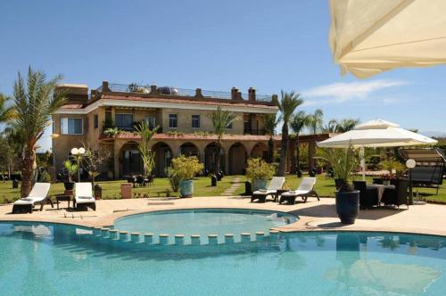 a swimming pool in front of a house at Palais Amador in Oulad Mazoug