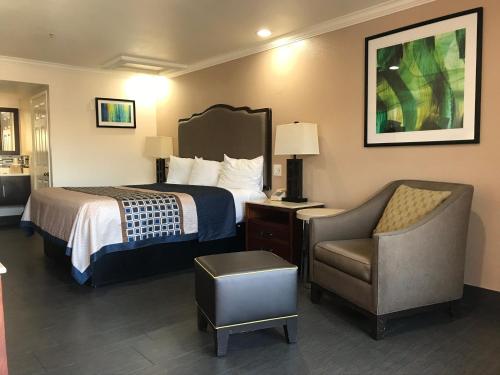 a hotel room with a bed and a chair at Economy Inn LAX Inglewood in Inglewood