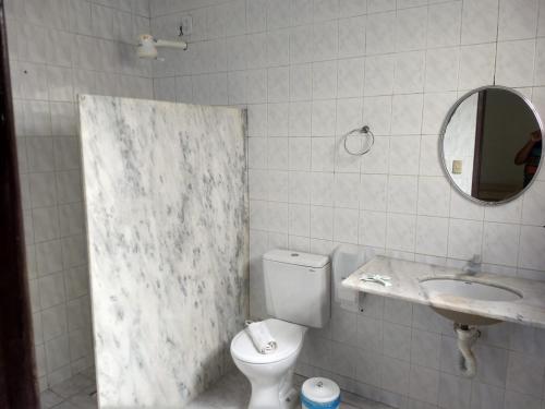 a bathroom with a toilet and a sink and a mirror at POUSADA BORE KOKO in Porto De Galinhas