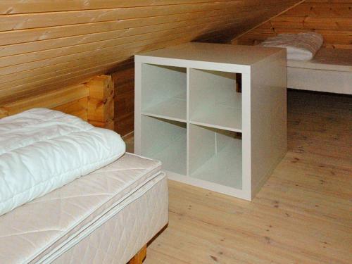 a bedroom with a white cabinet next to a bed at 5 person holiday home in VÅGLAND in Bårdset