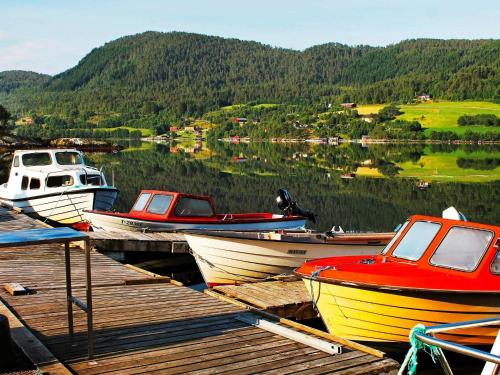 a group of boats are docked at a dock at 5 person holiday home in VÅGLAND in Bårdset