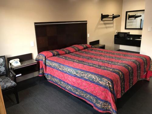 a hotel room with a large bed with a red blanket at Lotus Motel in Inglewood