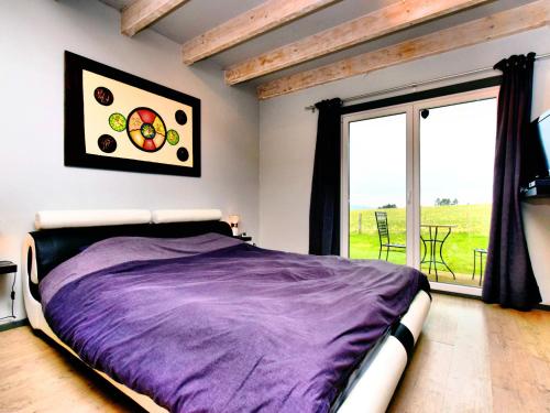 een slaapkamer met een bed en een groot raam bij Villa with heated outdoor pool and sauna in Manhay