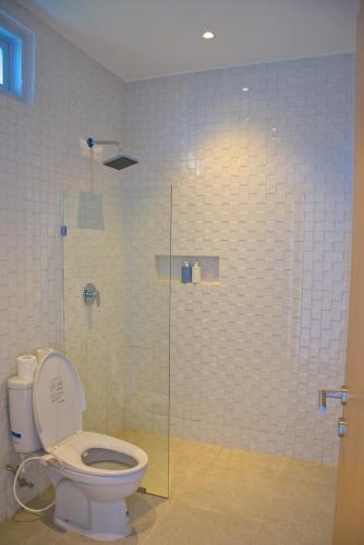 a bathroom with a toilet and a glass shower at Beluran Panorama in Tabanan
