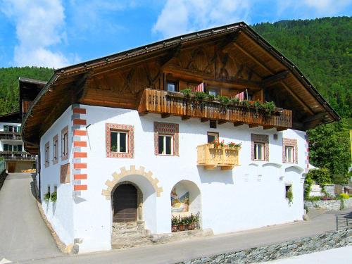 a white building with a balcony and windows at Oberwirtshof in Rifiano