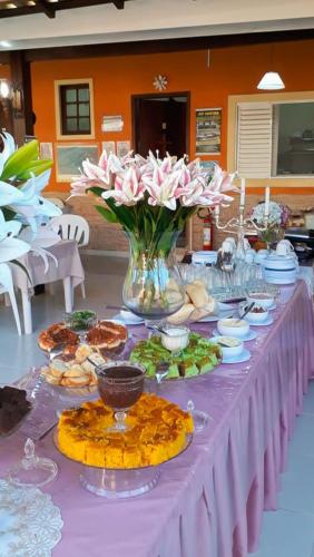 a purple table with food and flowers on it at Pousada Quatro Estações Paraty in Sertão do Taquari