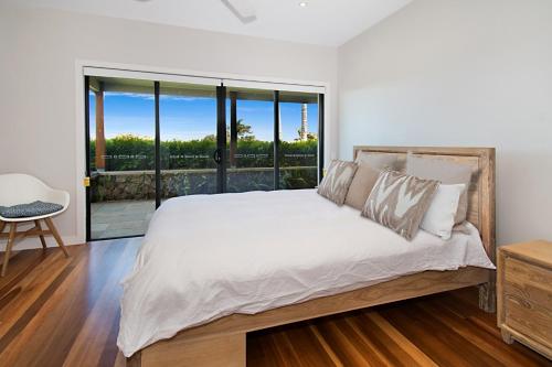 a bedroom with a large white bed and a window at Ferncrest in Fernleigh