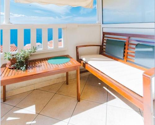 einen Balkon mit zwei Bänken auf einer Yacht in der Unterkunft Apartments Mari - sea view apartments in Tice