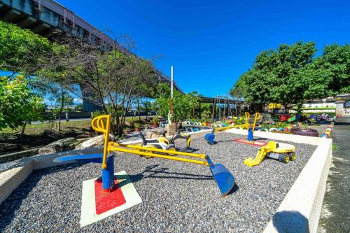 a playground with yellow and blue swings in a park at Sweetheart Homestay in Luodong