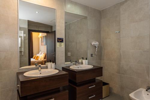 a bathroom with two sinks and a large mirror at Forest corner in silver mountain of poiana brasov in Poiana Brasov