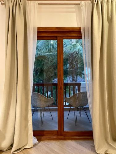 a room with a window with curtains and chairs at Amani Boutique Hotel - Small Luxury Hotels of the World in Paje