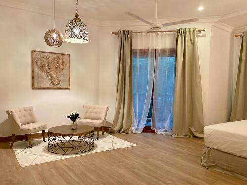 a bedroom with a bed and a table and chairs at Amani Boutique Hotel - Small Luxury Hotels of the World in Paje
