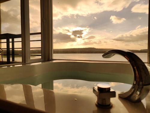 a bath tub with a faucet in front of a window at Lovestar Lakeside Hotel - Starlight Building in Hengchun