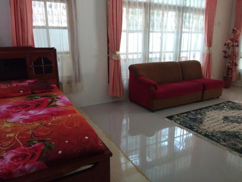 a living room with a bed and a couch at Homestay Anggur in Bukittinggi