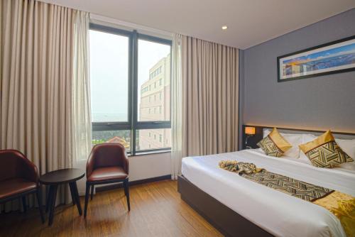 a hotel room with a bed and a window at SK LEGEND VUNG TAU HOTEL in Vung Tau
