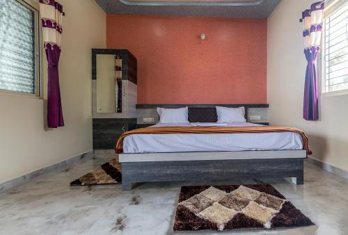 a bedroom with a large bed with red walls at Krishna Homestay Hampi in Hampi