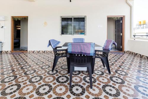 a dining room with a table and chairs on a tile floor at Krishna Homestay Hampi in Hampi