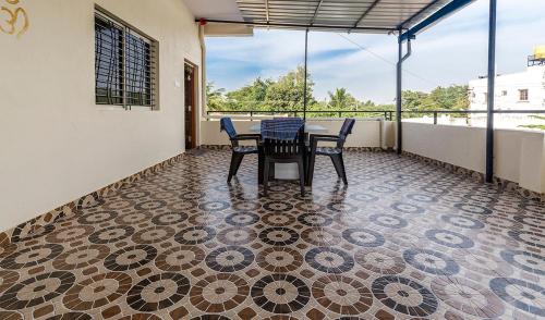 a patio with a table and chairs on a tiled floor at Krishna Homestay Hampi in Hampi