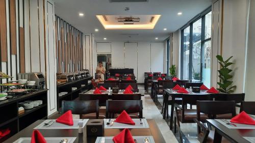um restaurante com mesas e cadeiras com guardanapos vermelhos em SK LEGEND VUNG TAU HOTEL em Vung Tau