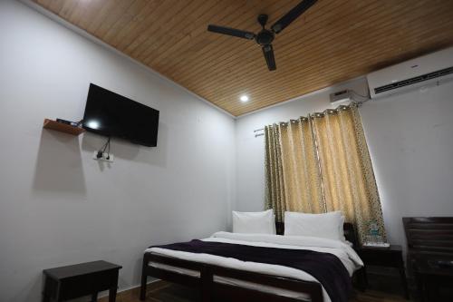 a bedroom with a bed and a flat screen tv at Le ROI Floating Huts & Eco Rooms Tehri in Tehri-Garhwāl
