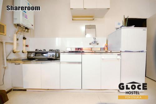 a white kitchen with a stove and a refrigerator at GLOCE 横須賀 シェアルーム NAVY BASE l Yokosuka Share room at NAVY BASE in Yokosuka