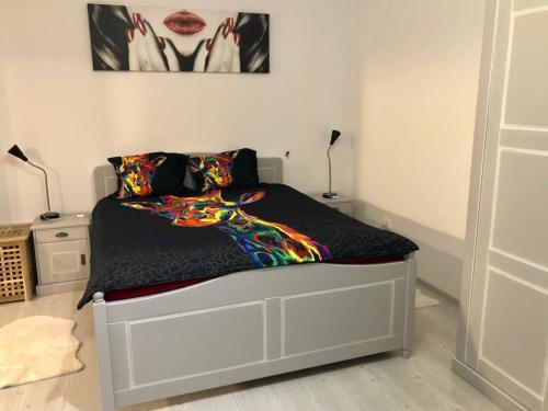 a bedroom with a bed with a colorful blanket at GOOD MOOD in Bragadiru