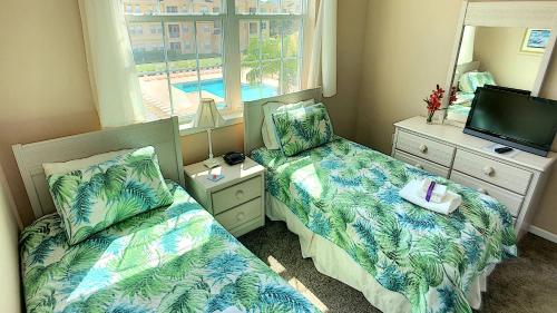 a small bedroom with two beds and a television at Pool Side Tree House in Davenport
