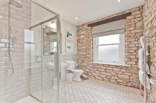 a bathroom with a glass shower and a toilet at Tithe Barn - Self Check In Hotel in Cockermouth