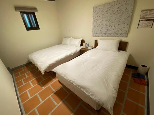 two beds in a small room with white sheets at The Chen Story II in Jincheng