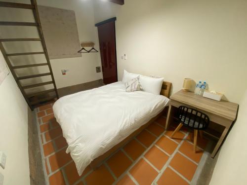 a small bedroom with a bed and a ladder at The Chen Story II in Jincheng