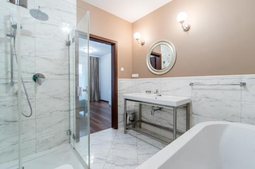 Un baño con bañera, lavabo y ducha. en Apartament Villa Resorts, en Dziwnówek