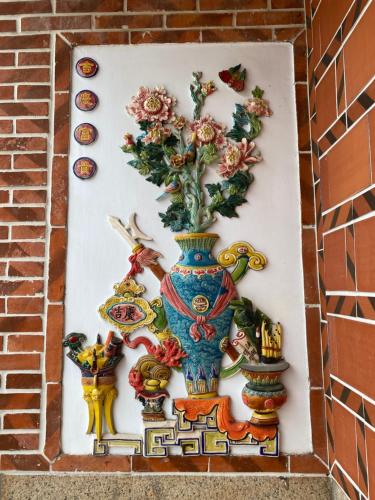 a painting of a vase with flowers on a wall at The Chen Story II in Jincheng