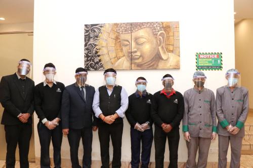a group of men wearing masks standing in front of a wall at Hotel Le Roi,Haridwar@Har Ki Pauri in Haridwār