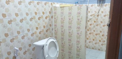 a bathroom with a urinal in a tiled wall at Khai Mook Homestay in Nan