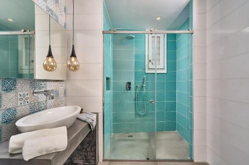 a bathroom with a glass shower and a sink at Arte & Mare Elia Luxury Suites and Villas in Elia Beach