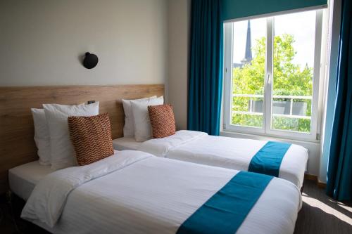Un pat sau paturi într-o cameră la Hotel Vauban
