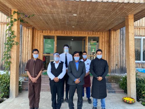 a group of men wearing masks in front of a building at Le ROI Floating Huts & Eco Rooms Tehri in Tehri-Garhwāl