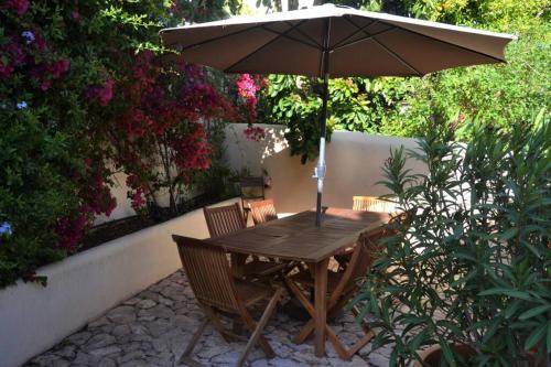 a wooden table and chairs with an umbrella at Sun in the City in Silves