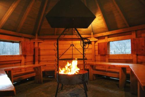 a room with a fire in a cabin with benches at DW Pod Jaworami - relaks - jacuzzi, sauna na wyłączność in Białka Tatrzanska