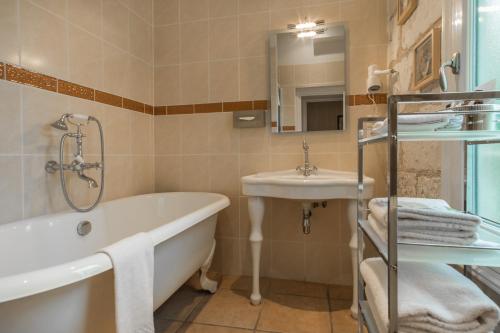 a bathroom with a tub and a sink at Le Pavillon des Lys - Hôtel Particulier in Amboise