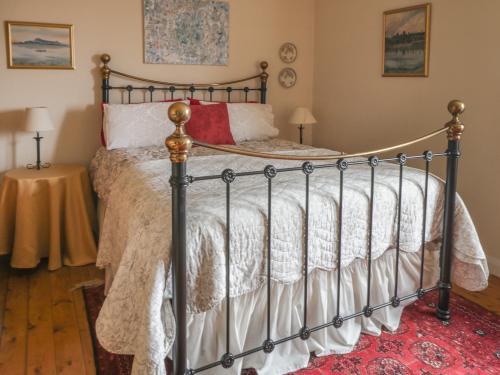a bedroom with a metal bed with white and red pillows at Lower Cross in Keighley